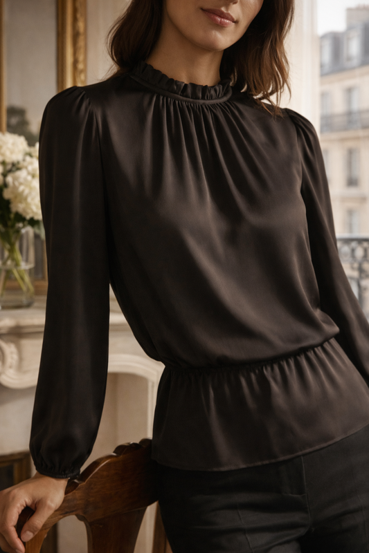 Elegant black blouse featuring a fluid silhouette, subtle neckline detailing, and gently cuffed sleeves.