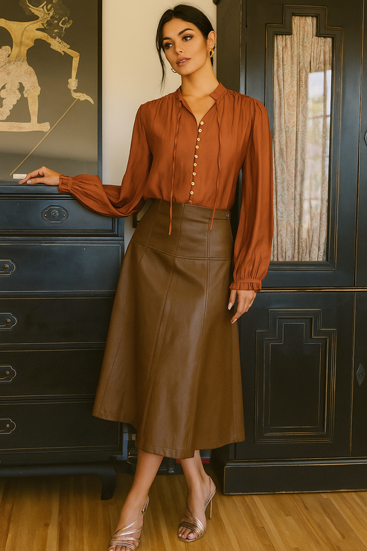 Woman wearing a rust-colored blouse and brown leather skirt 