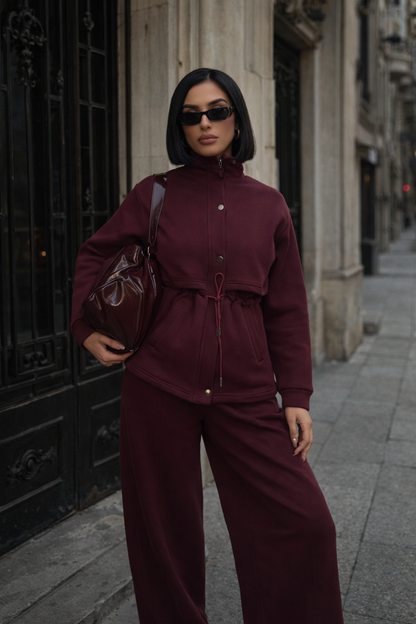 Burgundy matching lounge set styled with sunglasses and sneakers for a modern off-duty outfit.