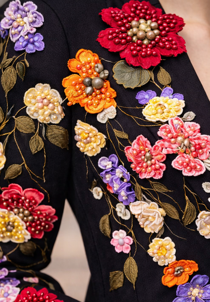 Close-up of black blazer featuring intricate multicolor floral embroidery with beaded details